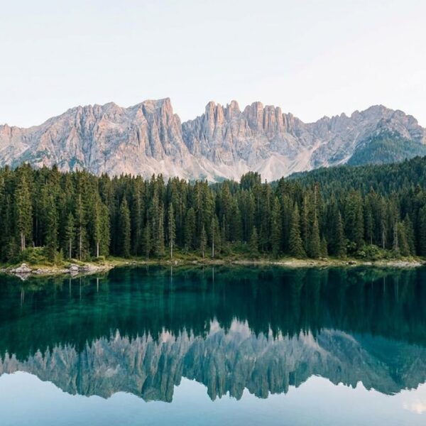 Peaceful mountain lake surrounded by pine forest and peaks