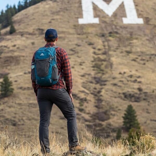 A hiker looking at a large M landmark on mountain